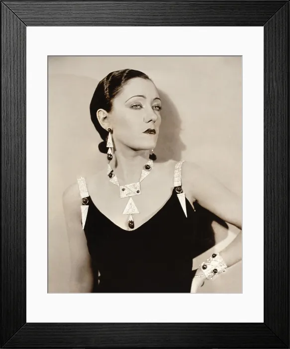 Framed Print : Actress Gloria Swanson models Art Deco jewelry c. 1930. She wears striking platinum geometric pieces studded with large gemstones