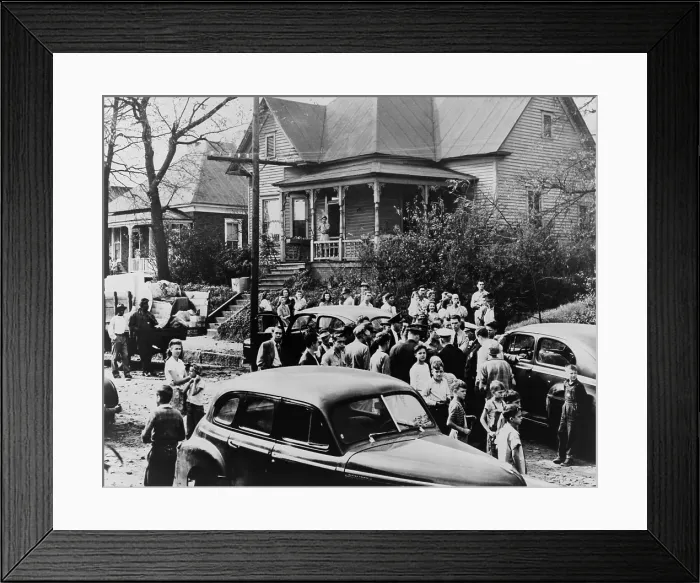 Framed Print : Police and White citizens gather in the street as an African American family moves in. In the background, two African American men stand by a truck loaded with furniture