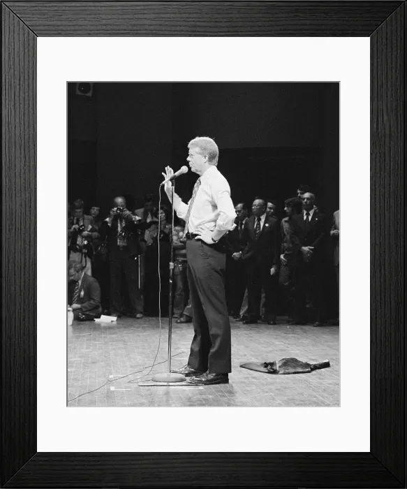 Framed Print : Jimmy Carter speaking in shirt sleeves at a Brooklyn College campaign stop in New York. His suit jacket which lies on the stage floor behind him. Sept 7 1976