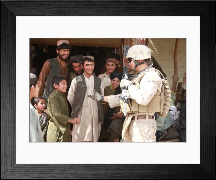 Framed Print : A U.S. Marine talks with Afghans in the Salaam Bazaar during to gather intelligence about seeking Taliban hideouts and bomb-making facilities around Now Zad Afghanistan