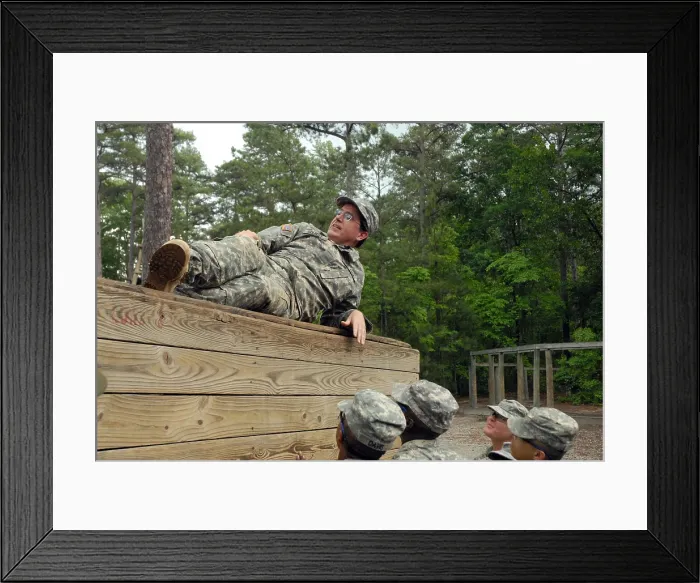 Framed Print : Political humorist Stephen Colbert tackles Basic Training. Army Private for a day Colbert rests atop an obstacle course wall rather than aiding his fellow Soldiers. June 2009