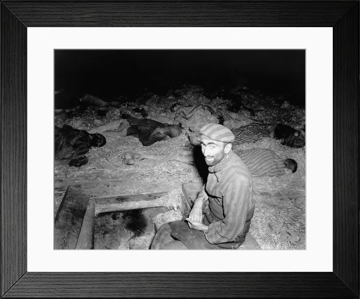 Framed Print : Emaciated Frenchman sitting among the dead in prison camp, Nordhausen, Germany after liberation by First U.S. Army on April 11, 1945