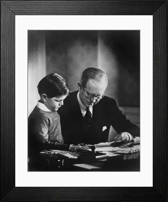 Framed Print : Ambassador to Great Britain, Joseph Kennedy, in his London study, helping his youngest son, Edward Kennedy, with his studies. Ca. 1938