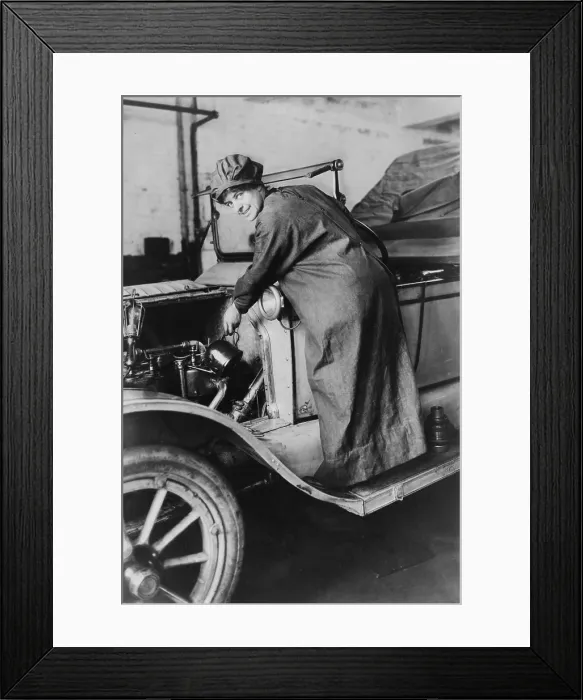 Framed Print : Female auto saleswoman, Rosalie Jones, attends to auto mechanics in a duster and hat in 1925
