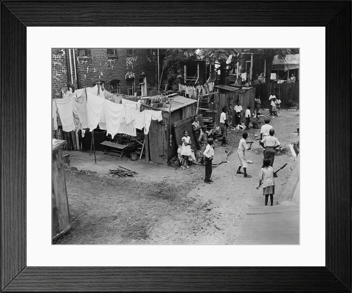 Framed Print : African American children playing baseball in an alley. The Washington DC slum, the London Court houses, had outhouses rather than indoor toilets. Ca. 1933-1940