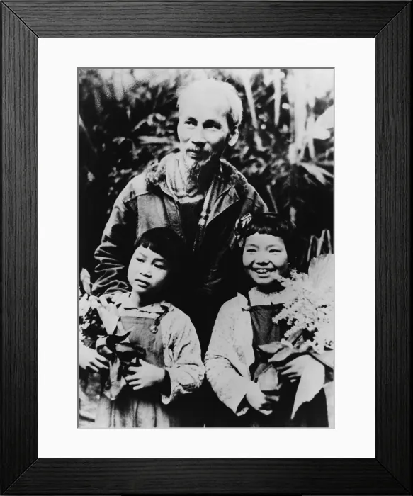 Framed Print : Ho Chi Minh (1890-1969), North Vietnamese leader revolutionary with his arms on the shoulders of two young girls. Ca. 1954