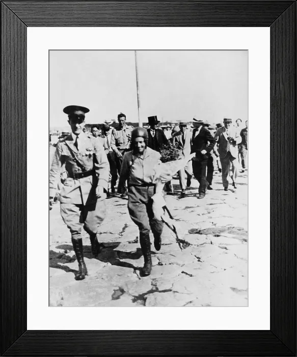 Framed Print : Mrs. Anne Morrow Lindbergh escorted by Japanese officer, with her husband, Charles (in background) after their arrival at Nemuro, Japan