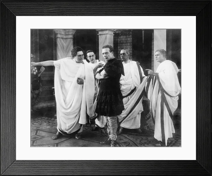 Framed Print : Amleto (Anthony) Novelli (1885-1924), Italian actor in a movie still from JULIUS CAESAR, 1914. Scene shows Novelli, as Caesar, surrounded by four Roman senators
