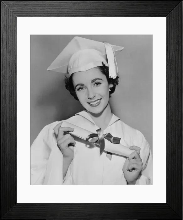 Framed Print : Elizabeth Taylor (b. 1932) wearing white cap and gown while holding a diploma from high school in Los Angeles. 1950 Framed Print : Elizabeth Taylor (b. 1932) wearing white cap and gown while holding a diploma from high school in Los Angeles. 1950