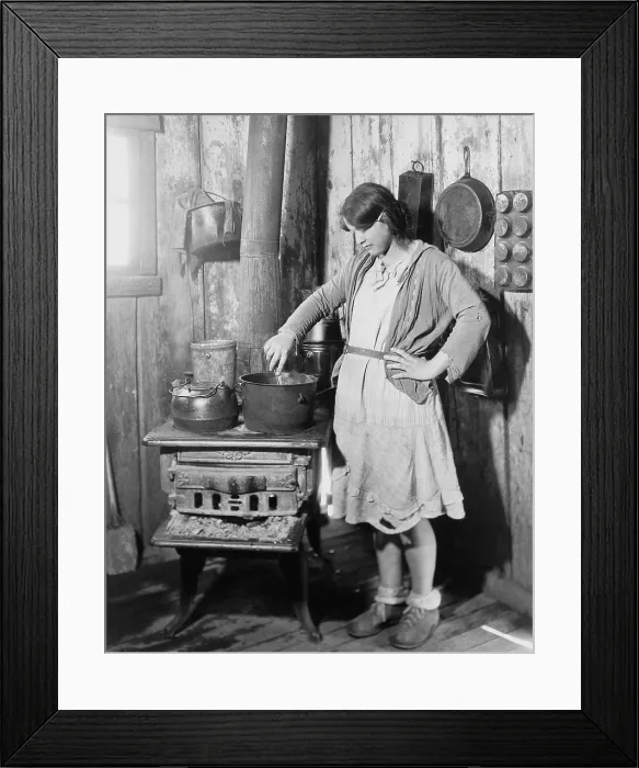 Framed Print : The teenage daughter of a an impoverished Arkansas farmer cooking on an old stove while her mother was in a tuberculosis sanitarium during the Great Depression