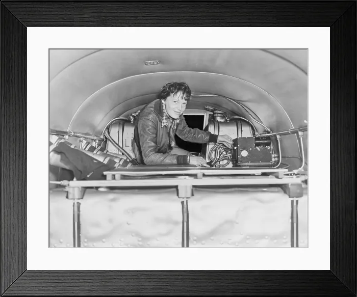 Framed Print : Amelia Earhart (1897-1937), checking equipment on her airplane. Ca. 1937