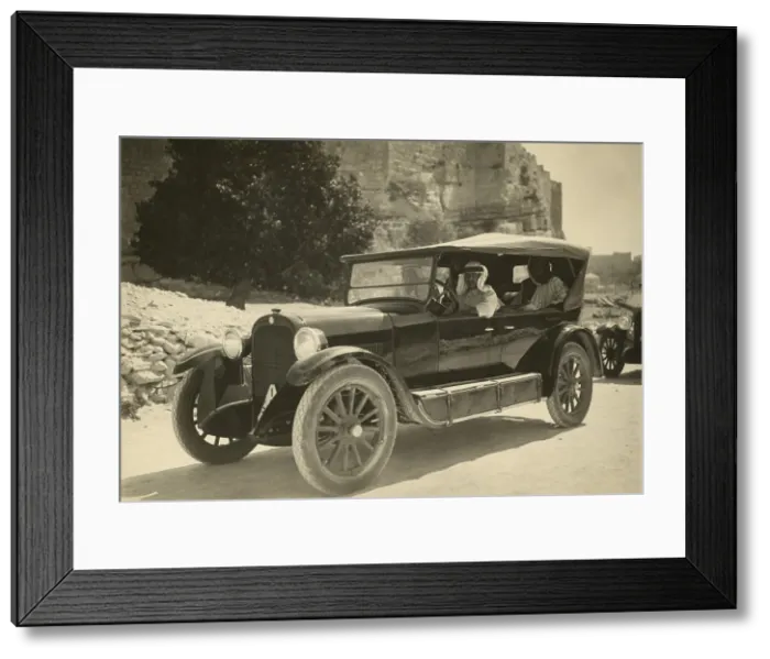 Framed Print : Arab men wearing traditional keffiyeh in a passenger car in the 1920s. On the running board tanks are fuel tanks for travel in areas without service stations