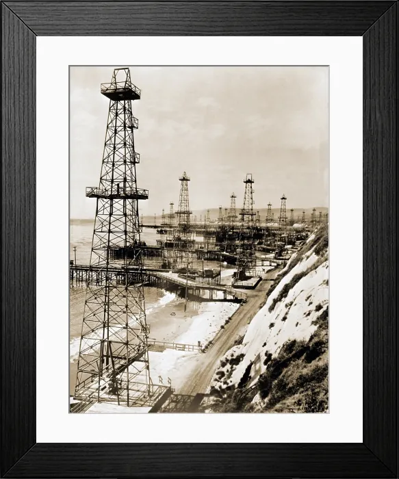 Framed Print : Oil well derricks on the beach along the California coast. Ca. 1944