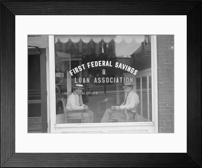 Framed Print : Two businessmen sit behind the storefront window of a Marion, Ohio, Savings and Loan Association