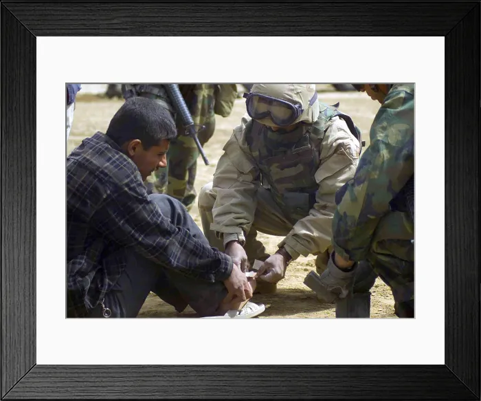 Framed Print : An Iraqi detainee receives a band-aid while under interrogation by a US Marine Corps in Al Shur Iraq during the first week of the Second Gulf War March 24 2003. (BSLOC_2011_12_76)