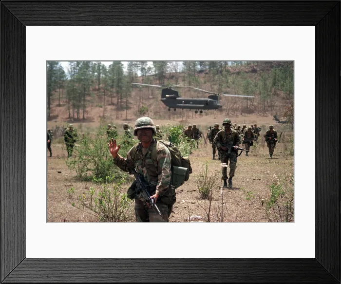 Framed Print : An 82nd Airborne Division soldier signals to his platoon as they advance across a field in Honduras after being inserted by a Chinook helicopter in Tamara Honduras
