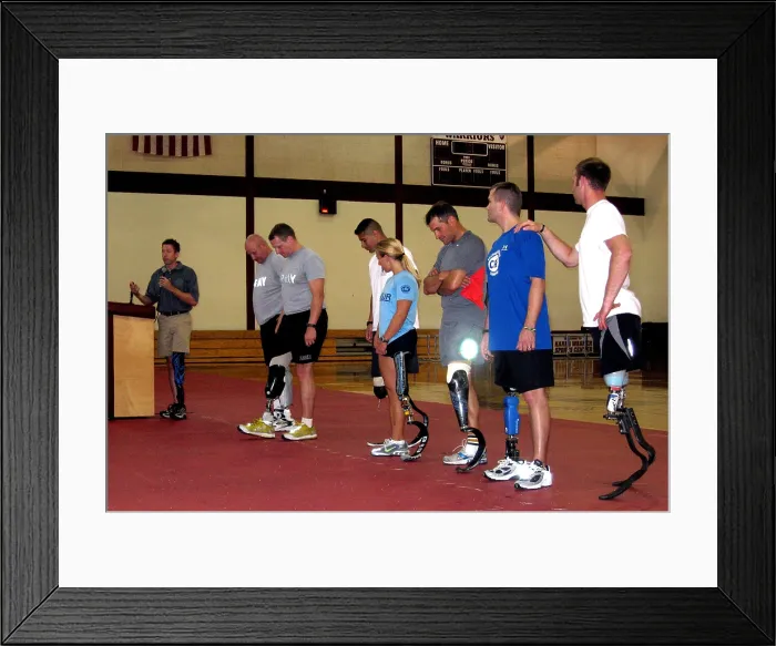Framed Print : Brian Frasure paralympian speaking at a Military Amputees Training workshop while flanked by seven soldiers wearing advanced artificial legs. Walter Reed Army Medical Center