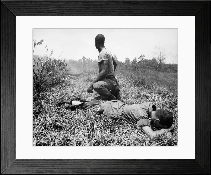Framed Print : Vietnam War. An African American Infantry medic treats a lieutenant's leg, that was burned by an exploding Viet Cong white phosphorus booby trap. 1966
