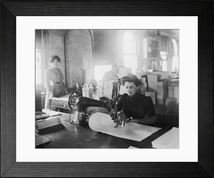 Framed Print : Middle-aged woman sewing on a belt driven Singer machine at the Richmond & Backus Company, Detroit, Michigan, ca. 1905 Framed Print : Middle-aged woman sewing on a belt driven Singer machine at the Richmond & Backus Company, Detroit, Michigan, ca. 1905