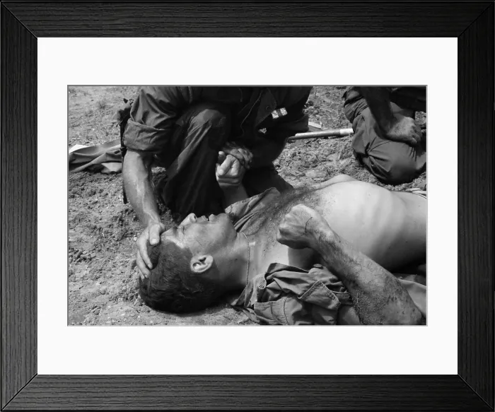 Framed Print : Vietnam War. US Marine wounded by a Viet Cong booby trap is comforted by a fellow Marine. 1967