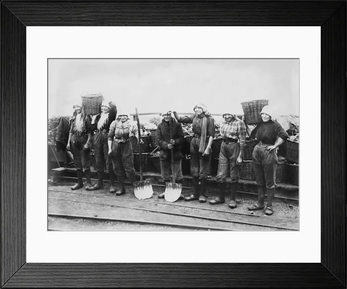 Framed Print : Belgian women coal miners dressed in trousers. They wear workers clogs and headscarves, and tight belts that emphasize their waists. Between 1900-1920