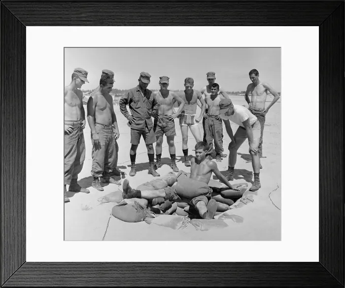 Framed Print : Vietnam War. US Marine Lieutenant instructs soldiers in an extreme leg and stomach muscle exercise performed over a sandbagged foxhole. Aug. 13, 1966