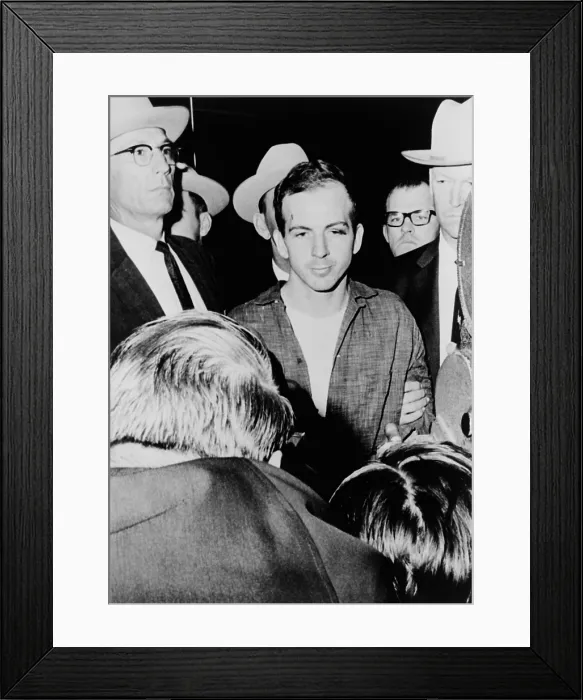 Framed Print : Lee Harvey Oswald escorted by officers at the Dallas Texas police headquarters shortly after his arrest for the assassination of President Kennedy. November 23 1963