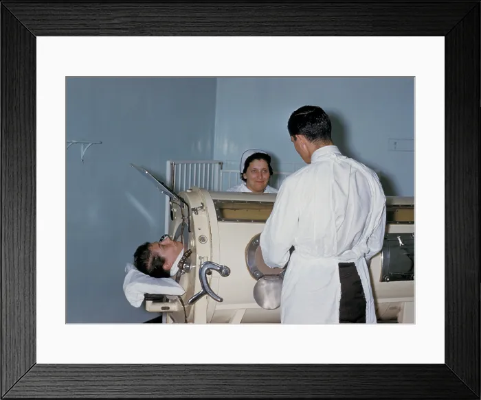 Framed Print : Hospital staff are examining a patient in a tank respirator, iron lung, during a Rhode Island polio epidemic