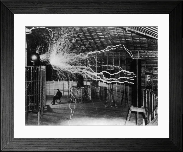 Framed Print : Nikola Tesla 1856-1943 created a double exposure photograph of himself reading undisturbed by a 22 foot long discharge of artificial lightning of millions of volts of electricity Framed Print : Nikola Tesla 1856-1943 created a double exposure photograph of himself reading undisturbed by a 22 foot long discharge of artificial lightning of millions of volts of electricity