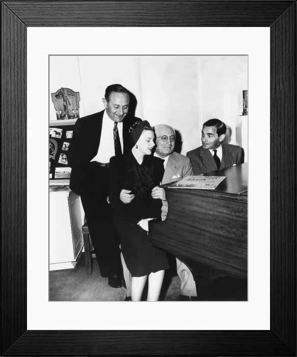 Framed Print : EASTER PARADE, from left: producer Arthur Freed, Judy Garland, studio head Louis B. Mayer, composer Irving Berlin reviewing songs in Mayer's office, 1948