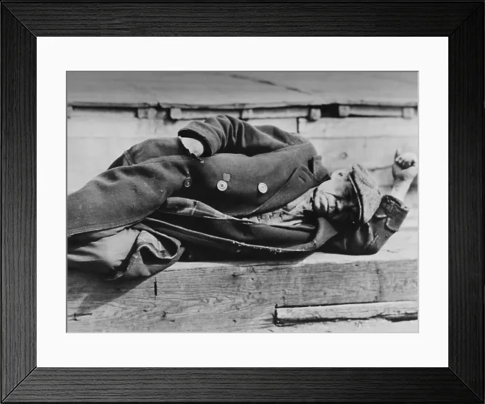 Framed Print : Man sleeping on the NYC docks, ca. 1930-31, by Lewis Hine. He wears a three piece suit under his worn overcoat, indicating his former white collar employment. (BSLOC_2013_7_15)