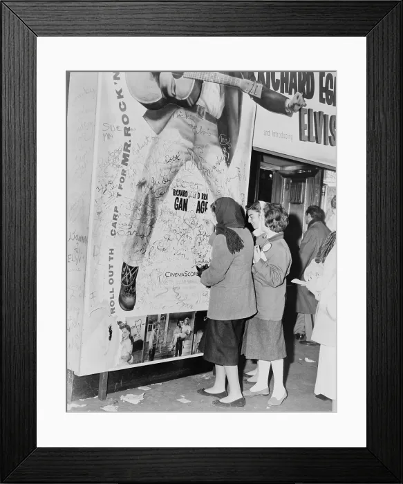 Framed Print : Teenage girls add graffitti to LOVE ME TENDER movie poster, Elvis Presley's film debut. 1956