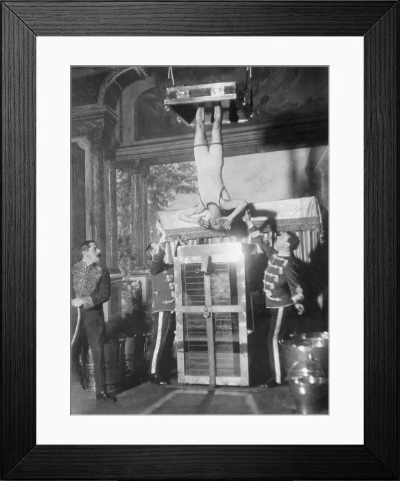 Framed Print : Houdini's Water Torture Cell escape. Houdini, with his ankles secured in stocks, was submerged and locked in place in full view of the audience. Ca. 1913 Framed Print : Houdini's Water Torture Cell escape. Houdini, with his ankles secured in stocks, was submerged and locked in place in full view of the audience. Ca. 1913