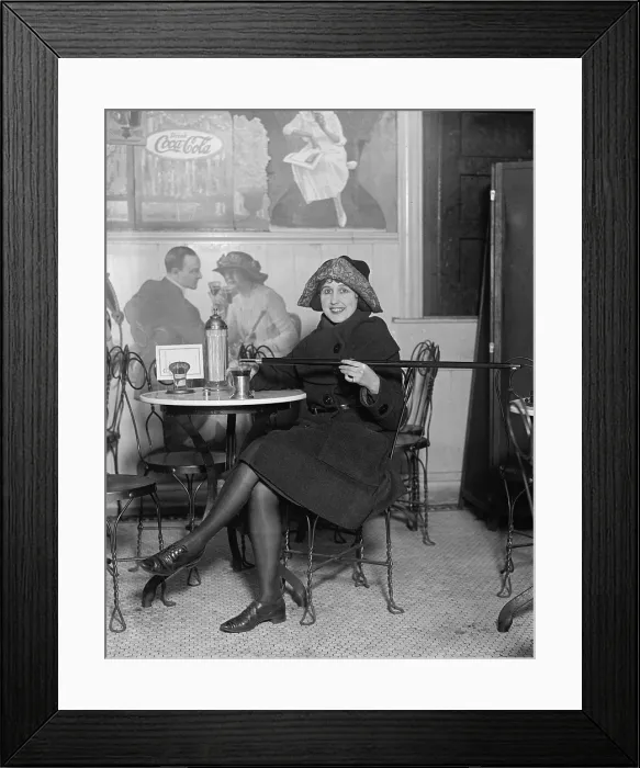 Framed Print : During Prohibition, a young woman fortifies her drink with alcoholic poured from a walking stick in 1922 Framed Print : During Prohibition, a young woman fortifies her drink with alcoholic poured from a walking stick in 1922
