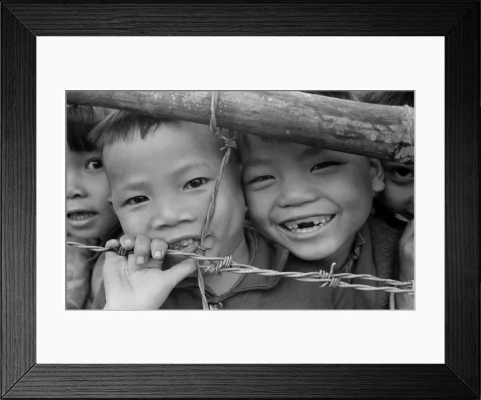 Framed Print : Smiling youngsters press against a barbed wire fence Framed Print : Smiling youngsters press against a barbed wire fence
