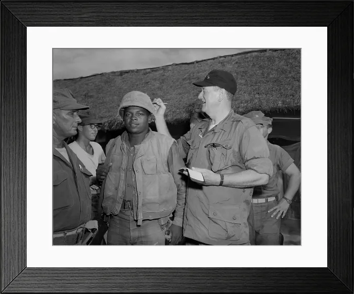 Framed Print : Actor John Wayne in Vietnam. John Wayne signs Private First Class Fonsell Wofford's helmet during his visit to the 3rd Battalion, 7th Marines, at Chu Lai. June 20, 1966