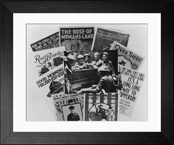 Framed Print : World War I soldiers gathered around a piano, framed by war song sheet music covers. Over There, It's a Long, Long way to Tipperary, are shown. 1917-18 Framed Print : World War I soldiers gathered around a piano, framed by war song sheet music covers. Over There, It's a Long, Long way to Tipperary, are shown. 1917-18