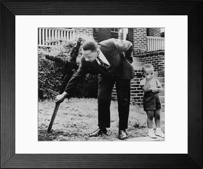 Framed Print : Martin Luther King, removes a KKK cross burned on lawn of his home, as his son Martin stands next to him, Atlanta, Georgia. April 27, 1960