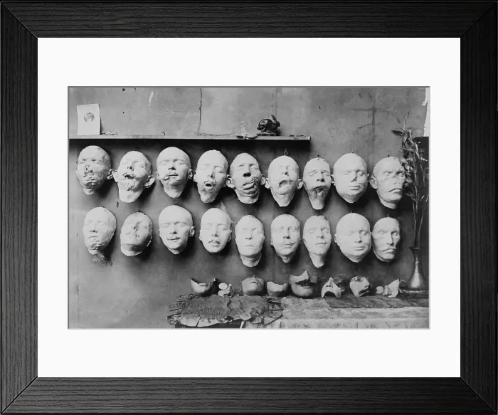 Framed Print : Plaster casts of WW1 soldiers mutilated faces in sculptor Anna Ladd studio. 1918. Below them are plaster molds of restored faces Ladd modeled