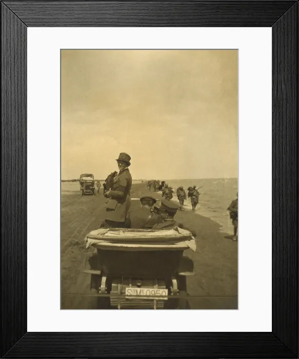 Framed Print : Photojournalist Helen Johns Kirtland in Europe after World War I. 1919. She photographs from an open car, riding on a beach with men in uniform as soldiers march past. Ca. 1919
