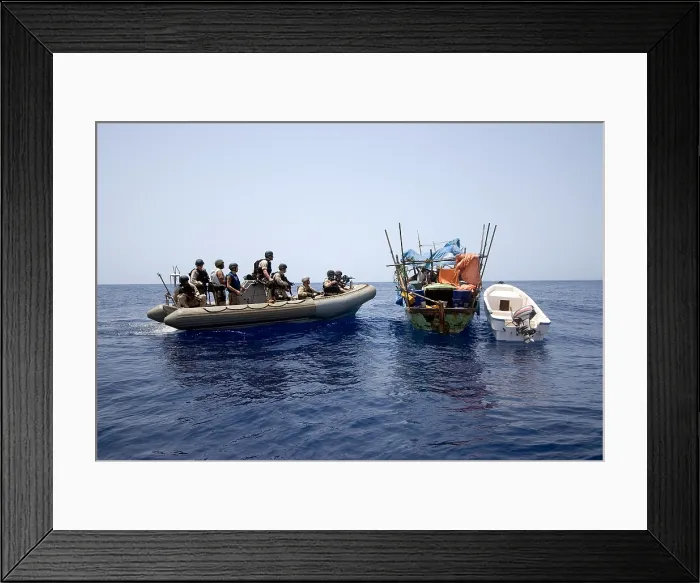 Framed Print : U.S. Navy and Coast Guard counter piracy personnel approach a suspect vessel while under way in the Gulf of Aden