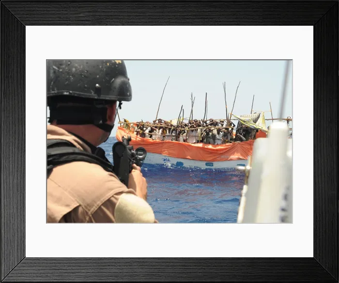 Framed Print : U.S. Sailor trains his gun on over twenty suspected pirates in a ramshackle boat the Gulf of Aden. April 17 2009. Photo by:Everett Collection(BSLOC_2011_6_191) Framed Print : U.S. Sailor trains his gun on over twenty suspected pirates in a ramshackle boat the Gulf of Aden. April 17 2009. Photo by:Everett Collection(BSLOC_2011_6_191)