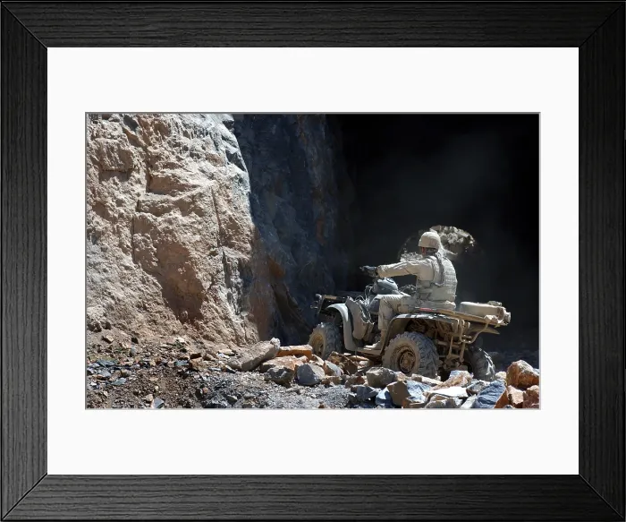 Framed Print : A U.S. Army soldier rides an All Terrain Vehicle into a cave to search for munitions on the outskirts of Kabul Afghanistan