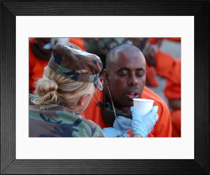 Framed Print : U.S. Military Police woman provides water to a thirsty detainee as they arrive at Camp X-Ray at Guantanamo Bay Naval Base. The prisoners were believed by the U.S Framed Print : U.S. Military Police woman provides water to a thirsty detainee as they arrive at Camp X-Ray at Guantanamo Bay Naval Base. The prisoners were believed by the U.S