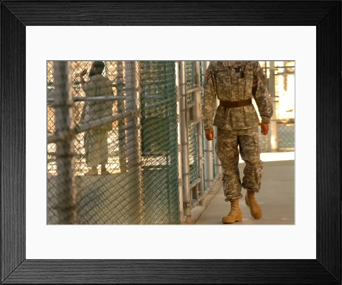 Framed Print : A U.S. Army Soldier stands guard as a detainee spends time in the exercise yard outside Camp Five at Guantanamo Bay Naval Base Framed Print : A U.S. Army Soldier stands guard as a detainee spends time in the exercise yard outside Camp Five at Guantanamo Bay Naval Base