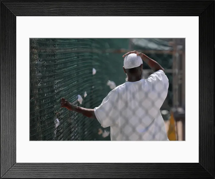 Framed Print : In Camp Delta prison at Guantanamo Bay Naval Base Cuba a detainee stands in the recreation yard. June 8 2010. Photo by:Everett Collection(BSLOC_2011_6_143)