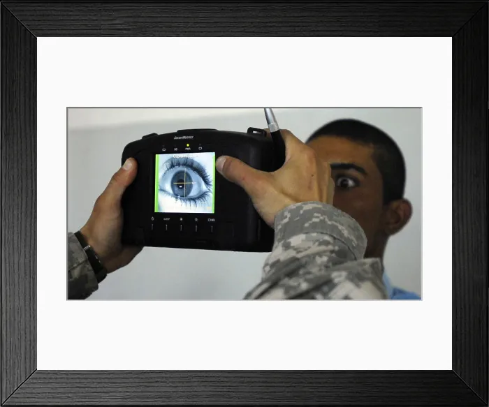 Framed Print : An Iraqi police recruit holds his eye open for a retinal scan administered by a US Soldier in Mahmudiyah Iraq May 30 2007. (BSLOC_2011_12_288) Framed Print : An Iraqi police recruit holds his eye open for a retinal scan administered by a US Soldier in Mahmudiyah Iraq May 30 2007. (BSLOC_2011_12_288)