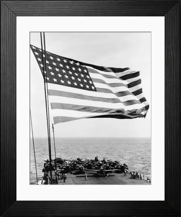 Framed Print : U.S. flag waving in foreground over flight deck of an escort carrier on July 16, 1943