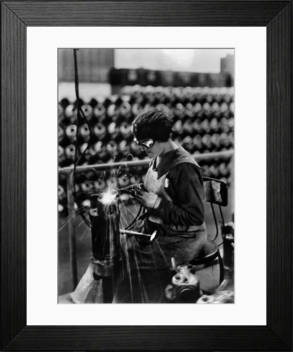 Framed Print : American woman performing acetylene welding on cylinder water jacket, a container filled with water that surrounds a machine, such a machine gun, to cool it. World War I. 1918