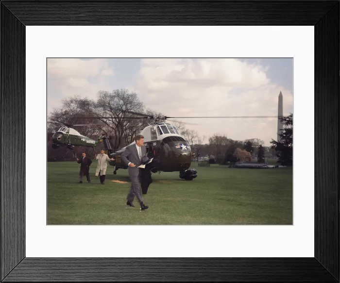 Framed Print : President Kennedy returning to the White House via Marine Helicopter. He is followed Secret Serviced Chief, Jerry Behn, and Press Secretary, Pierre Salinger. April 4, 1961